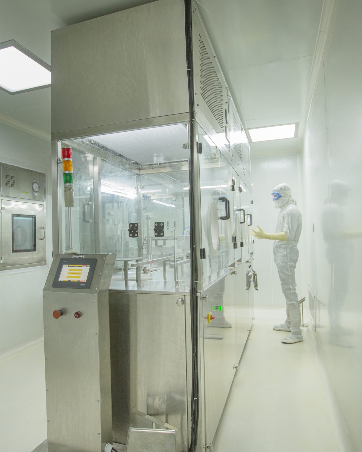 Regenix sterile fill-finish line in cleanroom, with technician in full gown alongside the filling machine