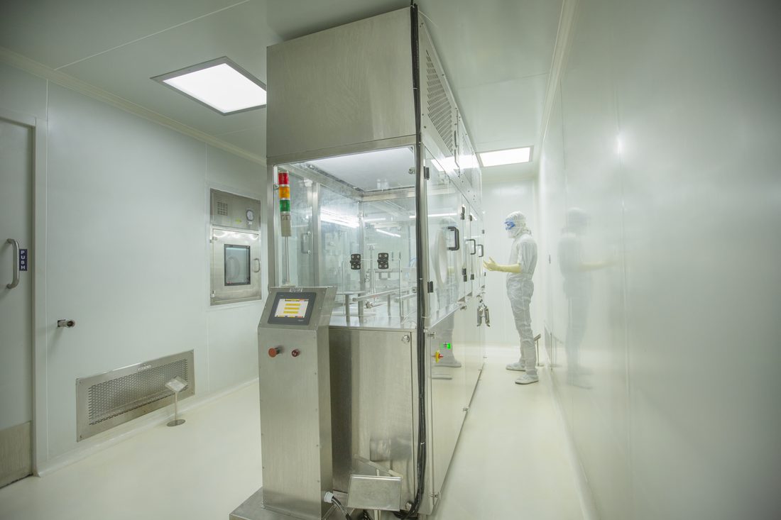 Sterile fill-finish line with technician in full cleanroom gown at the MEPZ-SEZ Chennai facility